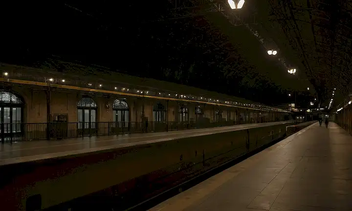 Escena nocturna de la estación de tren de Atocha, pasillos vacíos, plataformas diminutas, equipaje abandonado, y un sentido de eeriness, con un toque de misterio, oscuridad y aislamiento